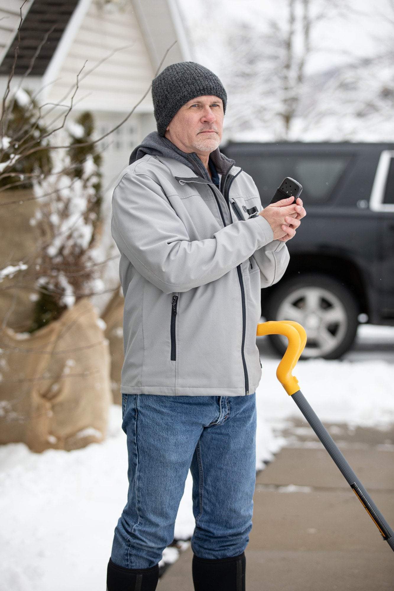 Man shoveling snow with the Black 12-Hour Refillable Hand Warmer in his hand