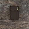 Lifestyle image of Brown Zippo Logo Windproof Lighter laying flat on a wooden background