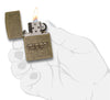 Zippo Stamp Antique Brass Lighter lit in hand.