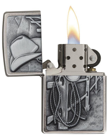 Resting Cowboy Windproof Lighter with its lid open and lit.
