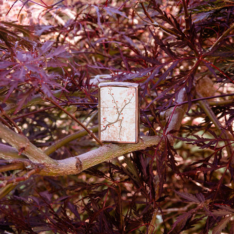 Lifestyle image Eastern Design Cherry Blossom High Polish Rose Gold Windproof Lighter standing in a tree.