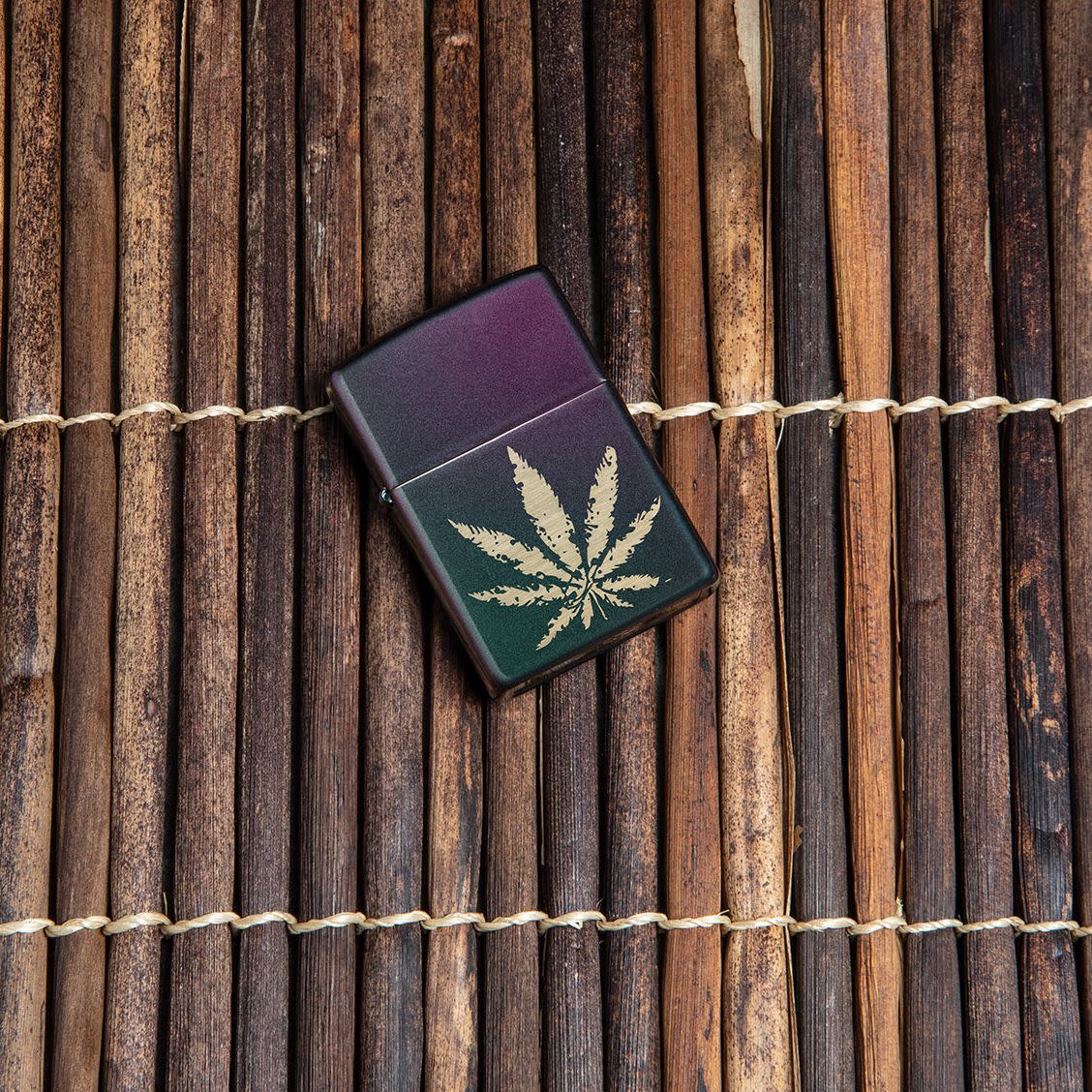 Lifestyle image of Iridescent Marijuana Leaf Windproof Lighter laying on wooden background