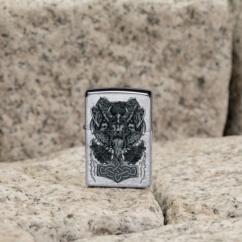 Lifestyle image of Viking Design Brushed Chrome Windproof Lighter standing on coble stone.
