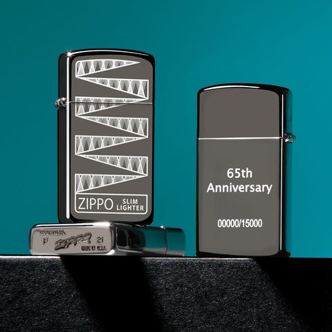 Lifestyle image of three Slim® Black Ice® 65th Anniversary Collectible Windproof Lighters. The lighter showing the front of the design, one showing the back, and one showing the unique bottom stamp.