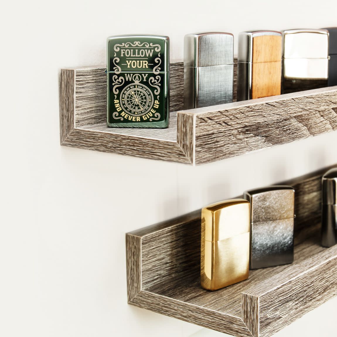 Lifestyle image of Follow Your Way Design High Polish Green Windproof Lighter standing on a shelf with a collection of Zippo lighters